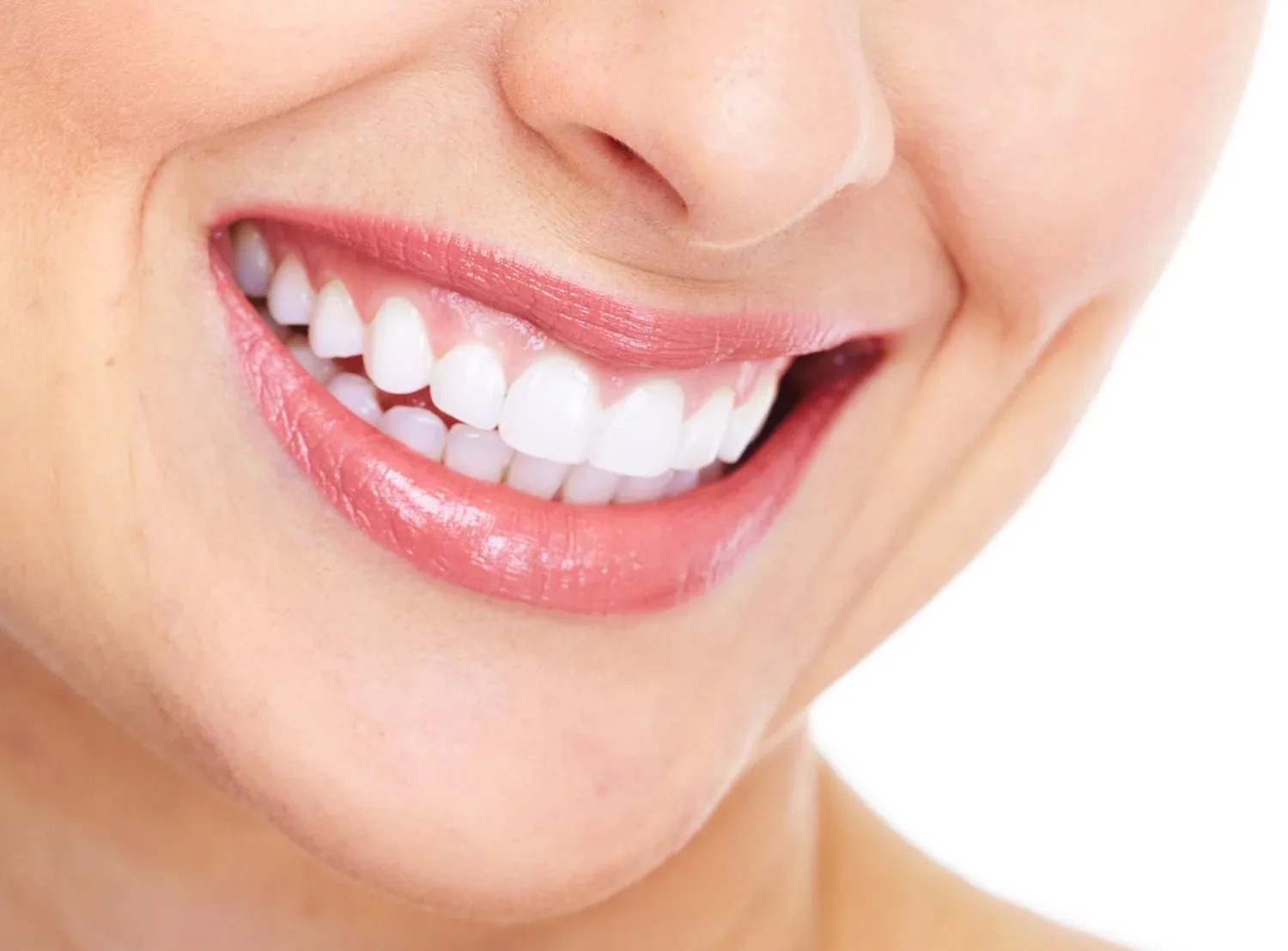 Close-up of a person's smile displaying straight, white teeth.